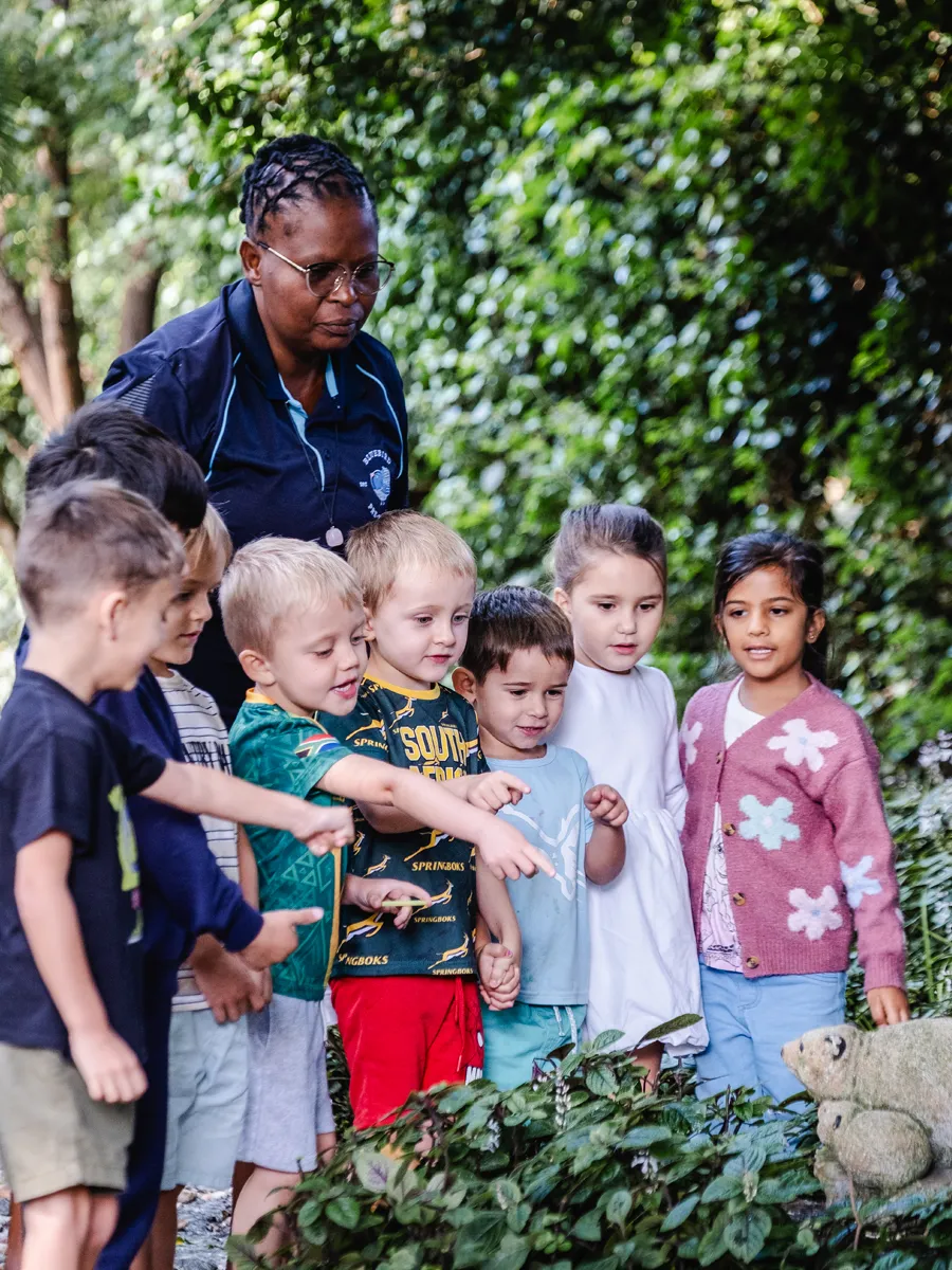 Curiosity grows outdoors as our children explore, observe and discover the wonders of nature together. Bluebird preschool teacher guiding a group of children as they explore nature together in the school garden.